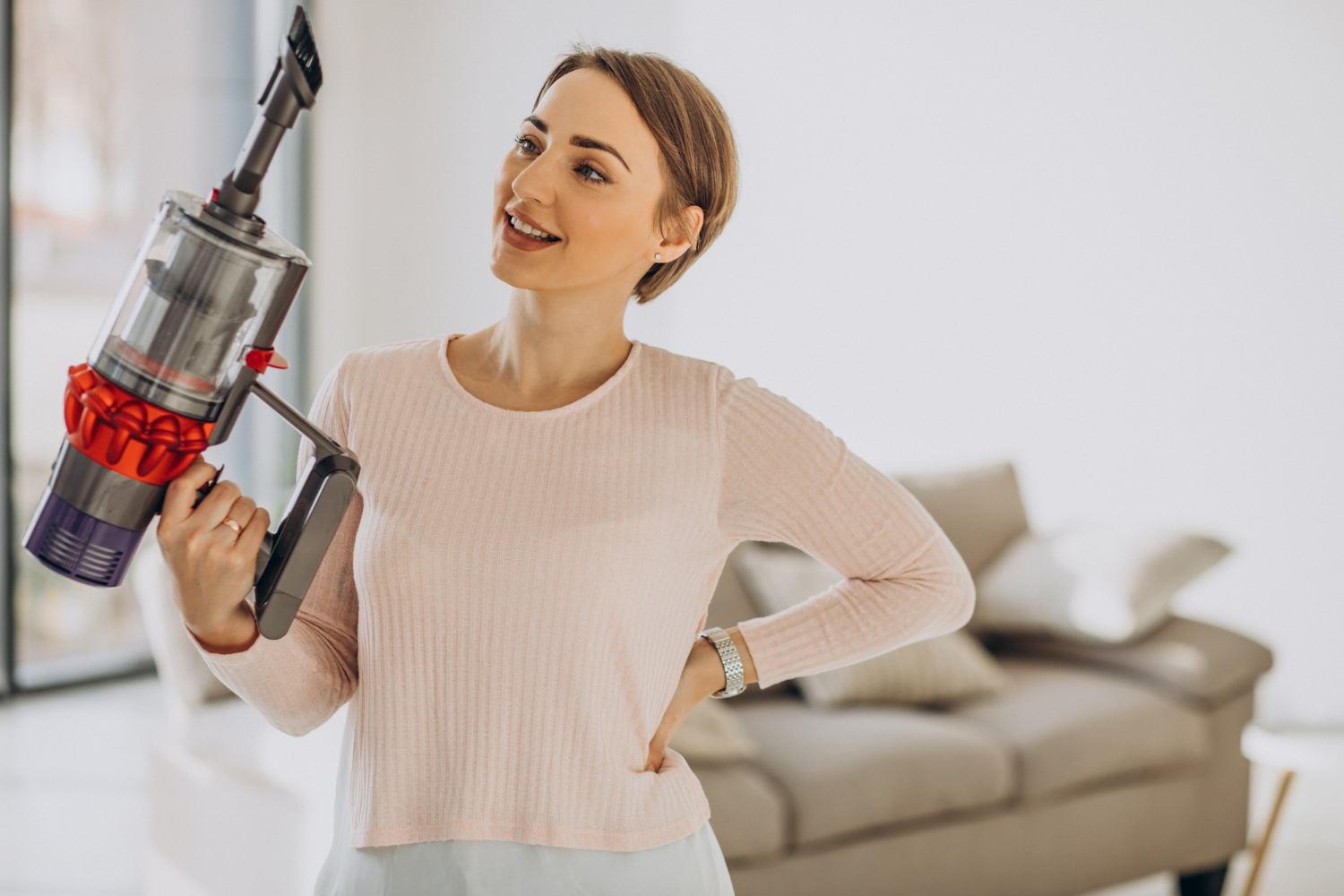 Young woman with rechargeable vacuum cleaner cleaning the house